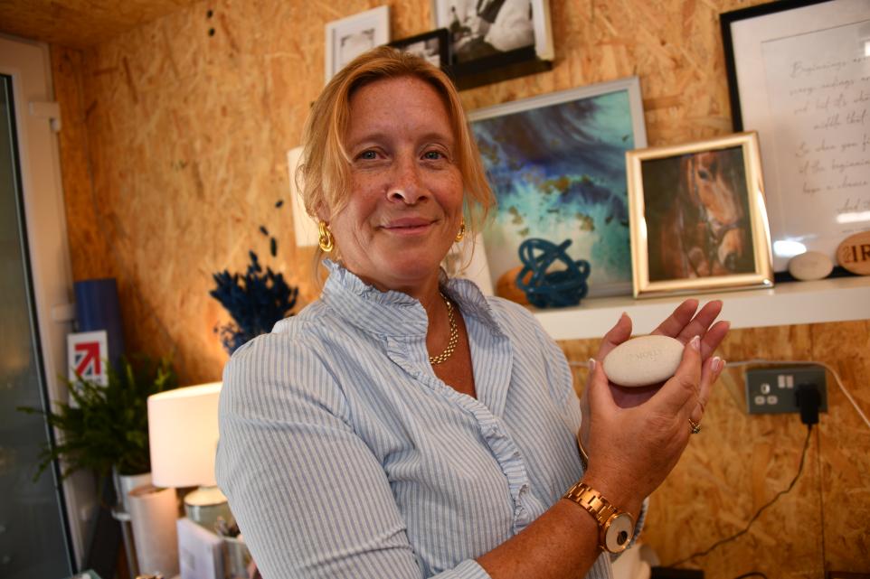 Founder of Afterstone - Victoria Marsh in her topsham office holding an engraved Afterstone pebble