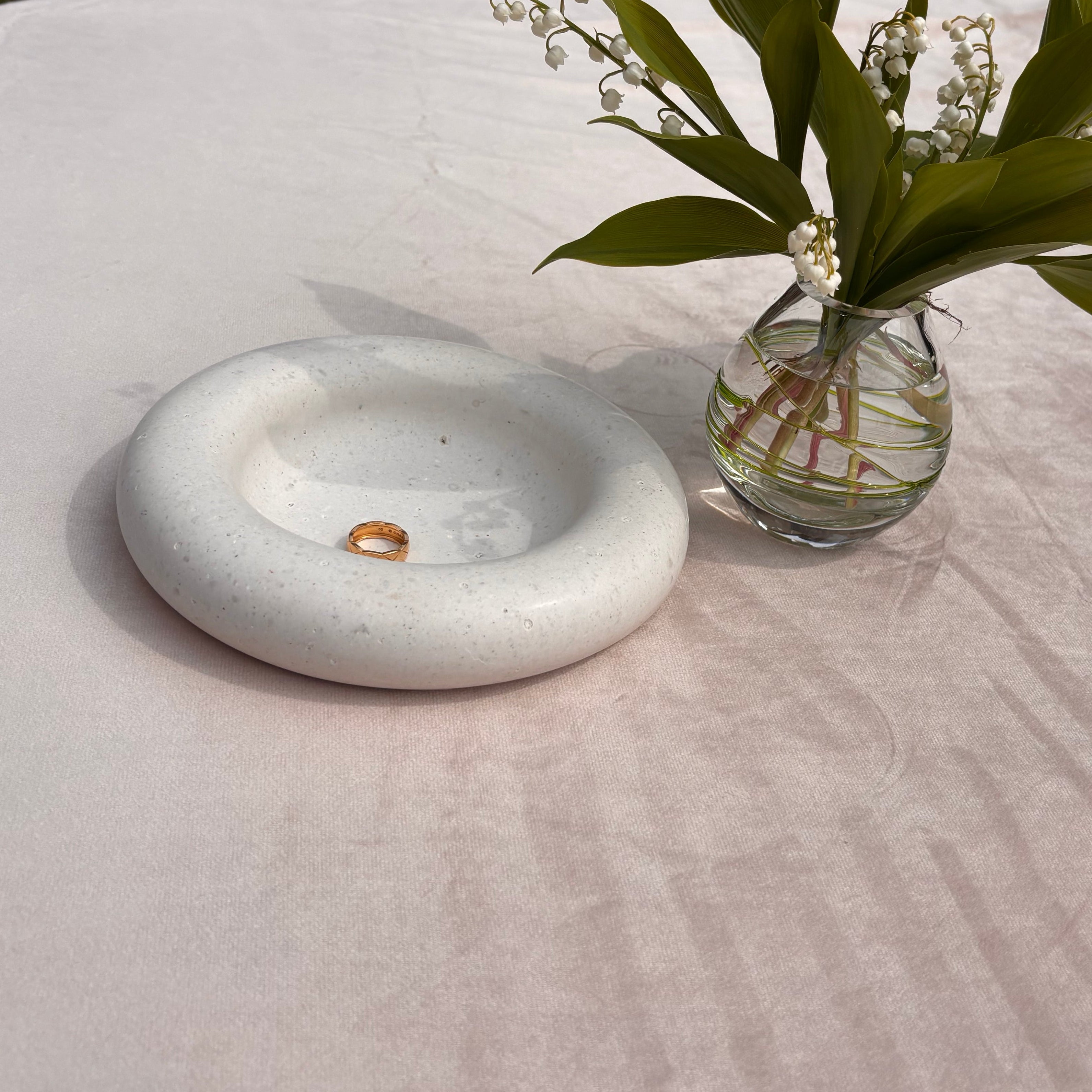 trinket bowl made from pet or human ash with lilly of the valley flowers in vase
