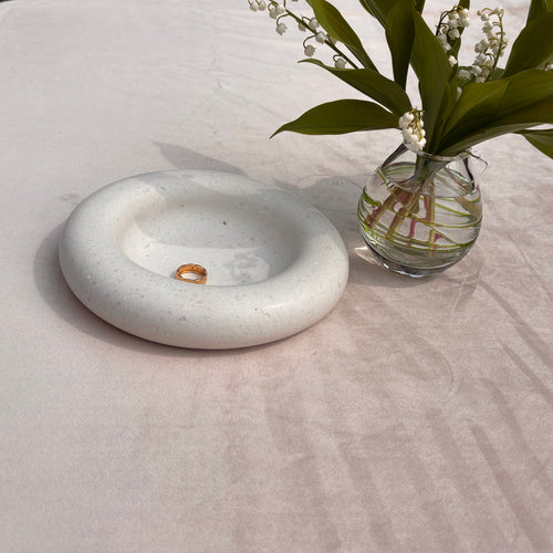 trinket bowl made from pet or human ash with lilly of the valley flowers in vase