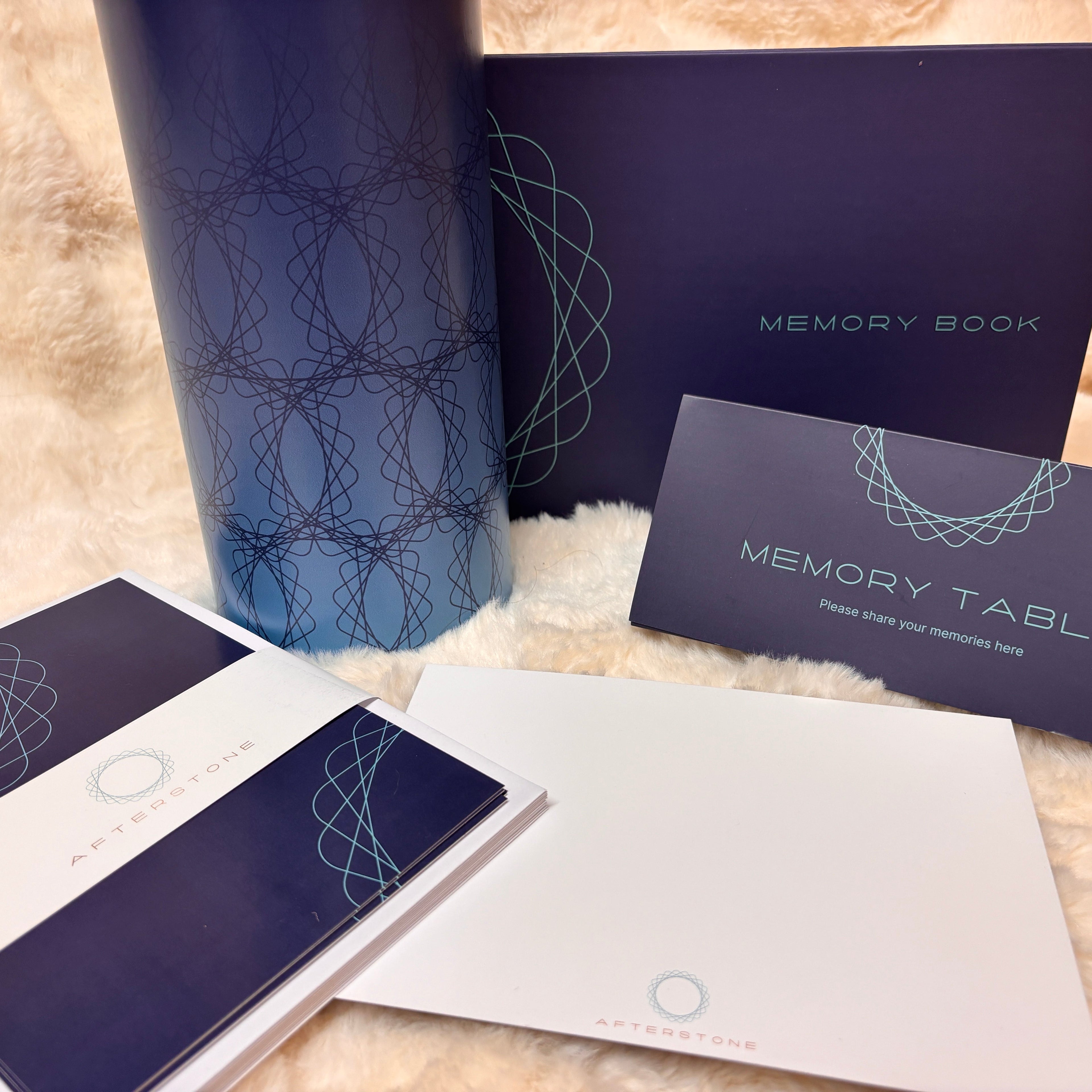 Memory Book set with a navy blue notebook, a matching memory table card, an instruction booklet, and a white envelope, all featuring a light blue geometric line pattern, arranged on a white faux fur surface.